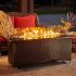 Lifestlye image montego fire table on a patio at night with added glass wind guard